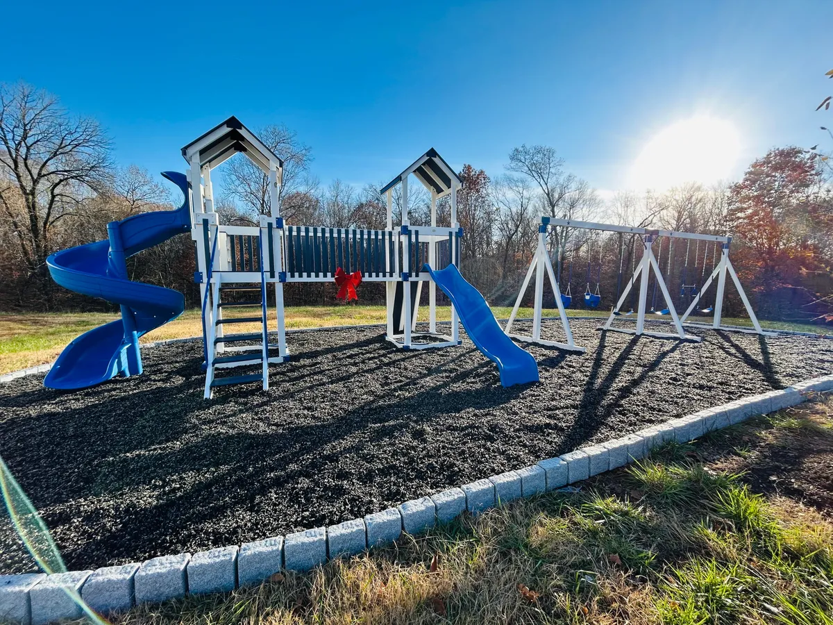 A vibrant playground scene featuring a playground structure with swings and a slide, set outdoors. The image evokes joyful play, with children likely engaging in activities such as swinging, sliding, and enjoying birthday parties or holiday gatherings.